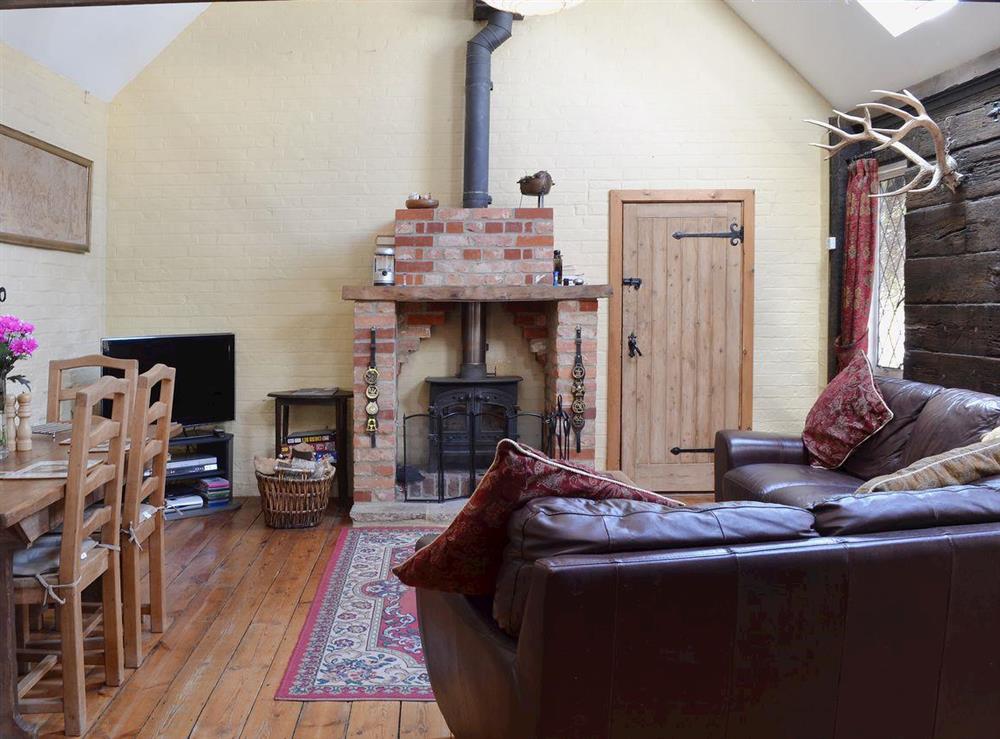 The wood floored living room with wood burning stove at Brook Barn in Shobley, Ringwood, Hants., Hampshire