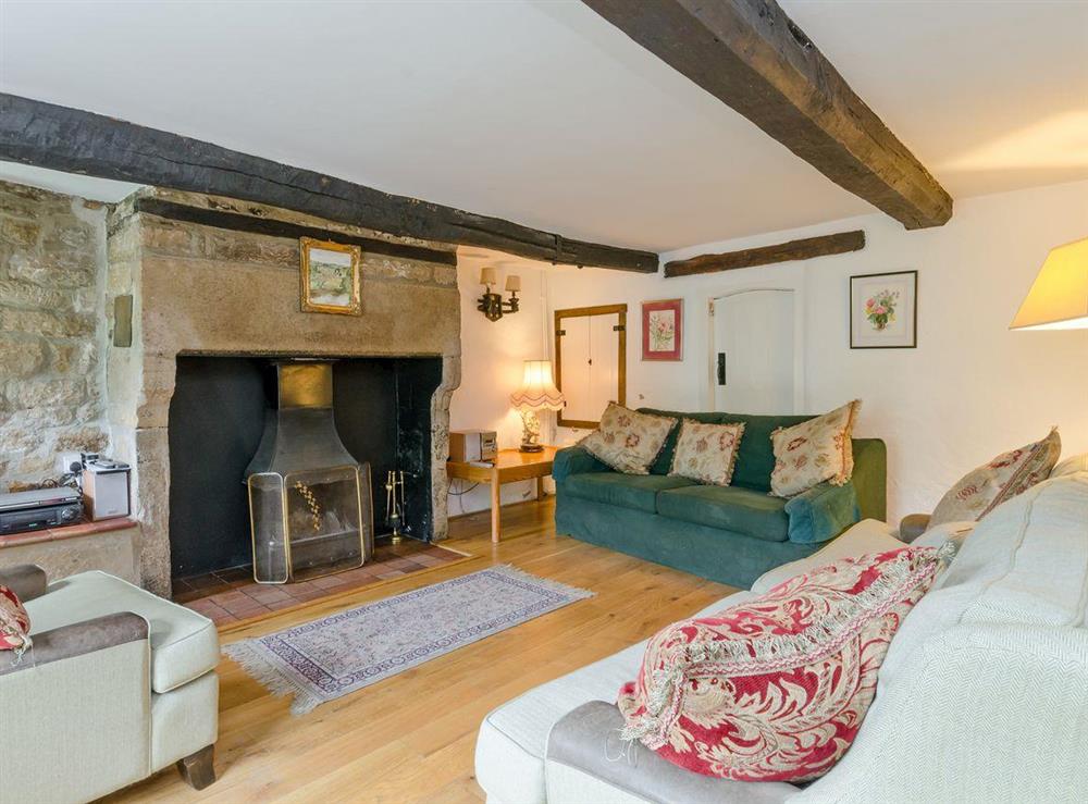 Living room with inglenook fireplace & open fire at Brookside Cottage in Beeley, near Chatsworth, Derbyshire