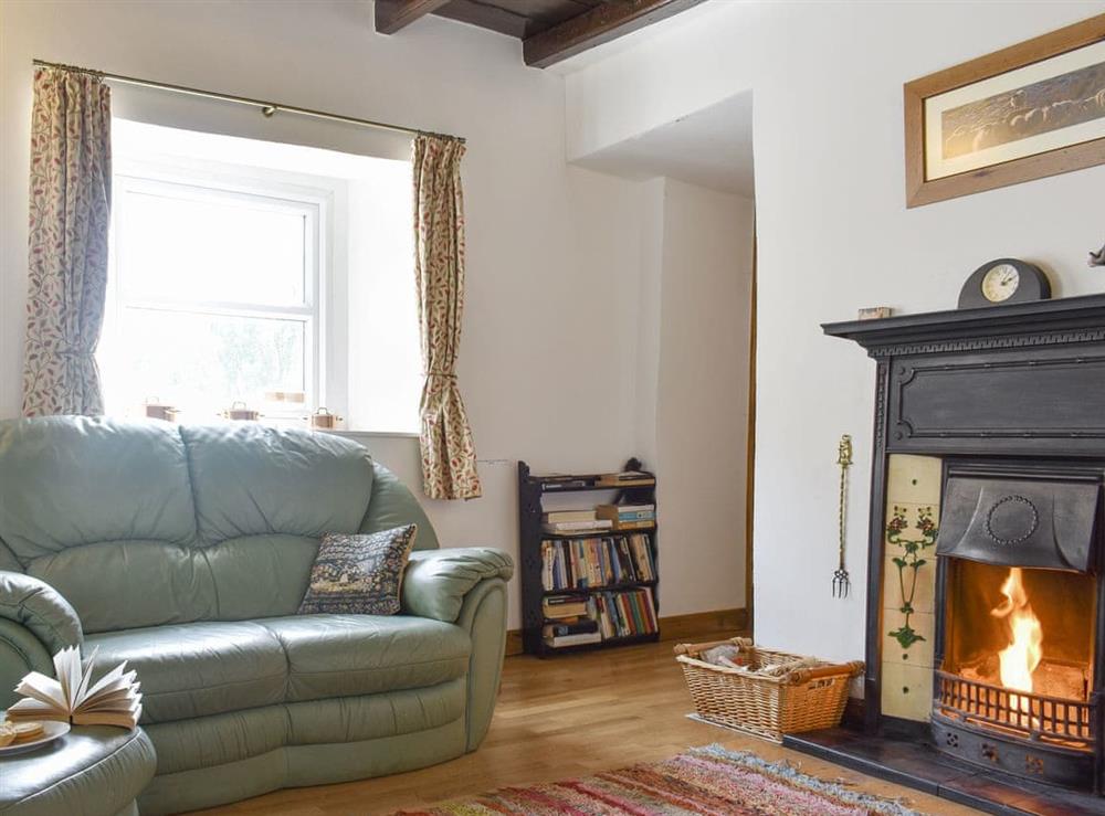 Inviting living room with open fire at Brookside in Langthwaite, near Reeth, North Yorkshire