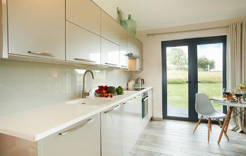 Open plan kitchen/dining/living area with bi-fold doors opening to private decked area (photo 2) at Broomers Barn, Ludlow