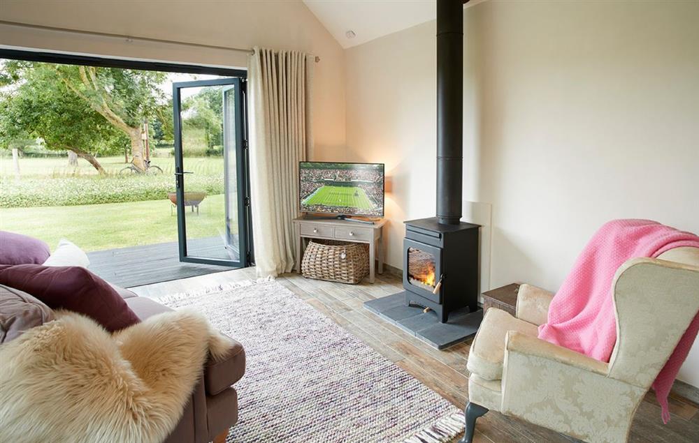 Open plan kitchen/dining/living area with bi-fold doors opening to private decked area (photo 3) at Broomers Barn, Ludlow