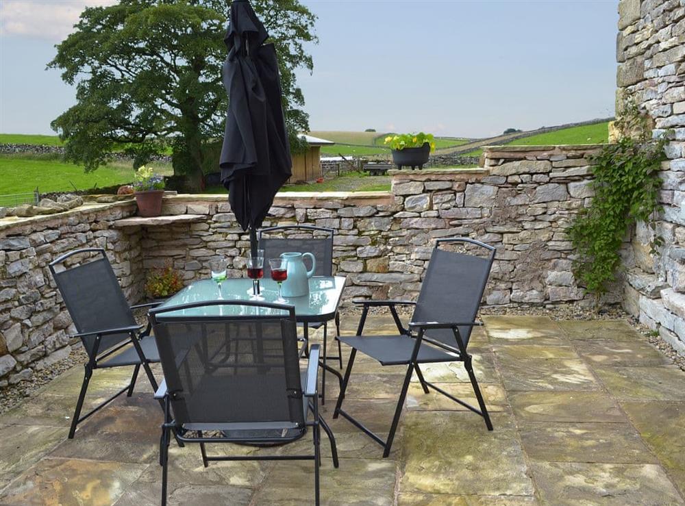 Paved patio area with table and chairs at Brow View Cottage in Ravenstonedale, near Kirkby Stephen, Cumbria