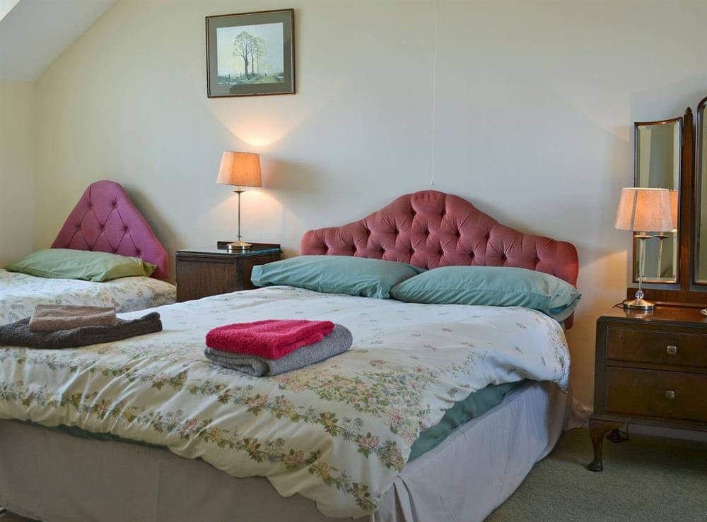 Comfortable bedroom with double bed and single bed at Bryn Hudol in Abererch, near Pwllheli, Gwynedd
