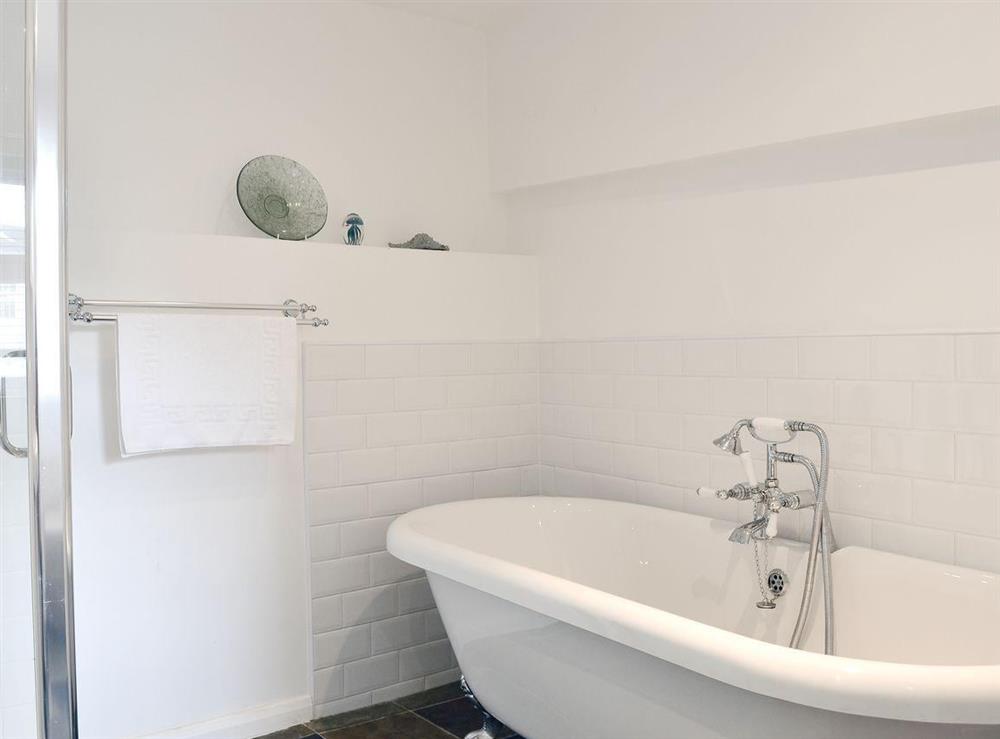 Bathroom with roll-top bath, shower cubicle and toilet at Bucca Cottage in Newlyn, near Penzance, Cornwall