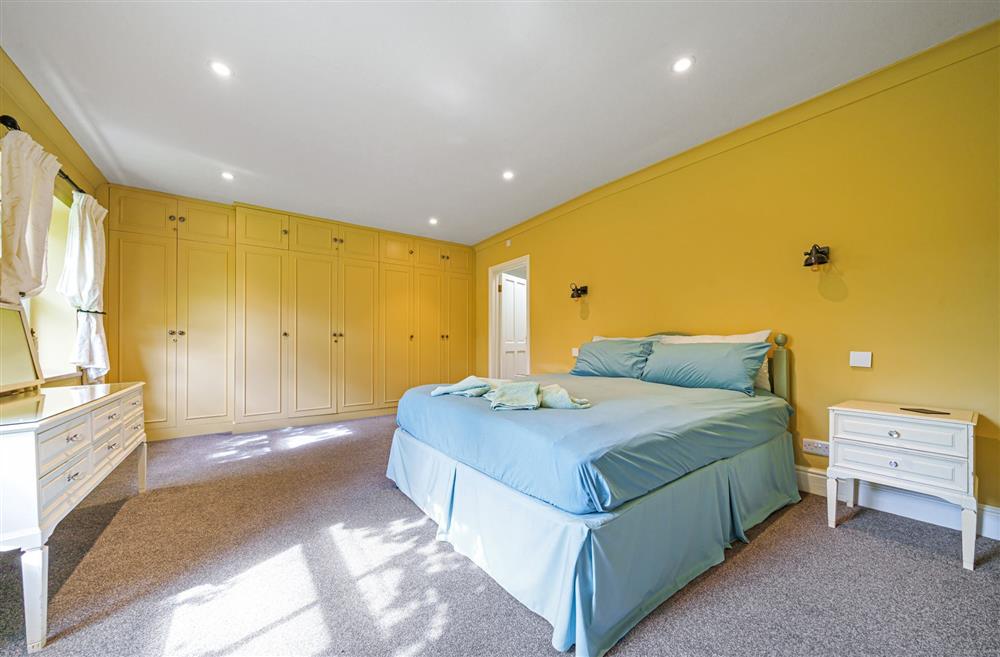 Bedroom one, with a 5’ king-size bed and en-suite bathroom at Bucknowle Lodge, Wareham