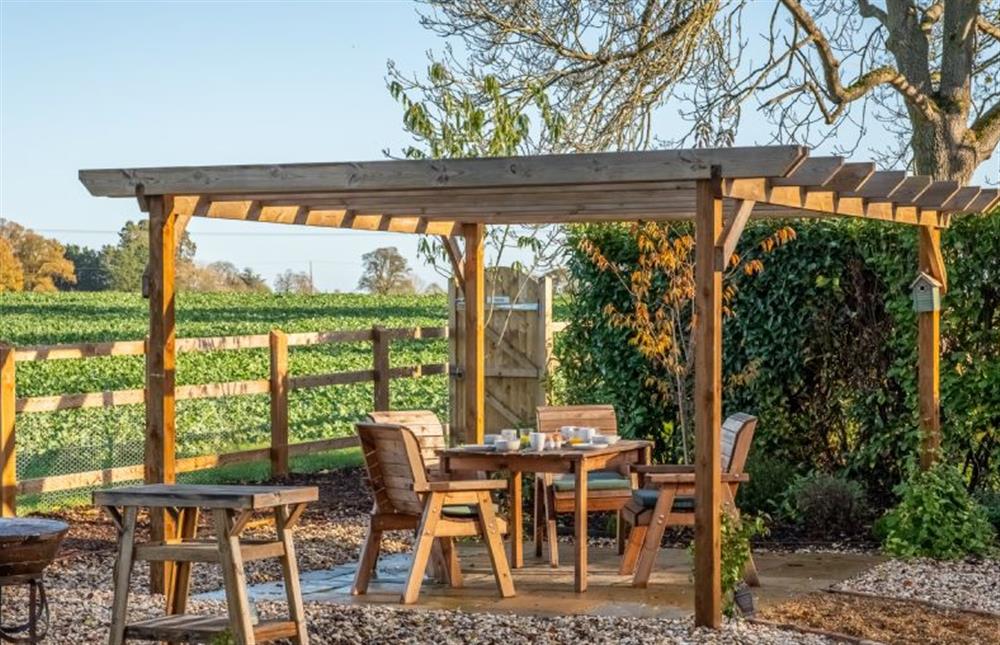 Outside is a lovely pergola for dining alfresco at Bumblebee Cottage, Culford Heath near Bury Saint Edmunds