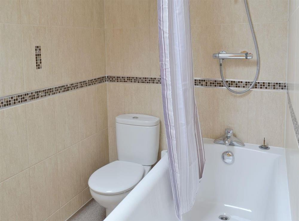 En-suite bathroom with shower over bath at Bumblebee Cottage in Skipsea, near Hornsea, North Humberside