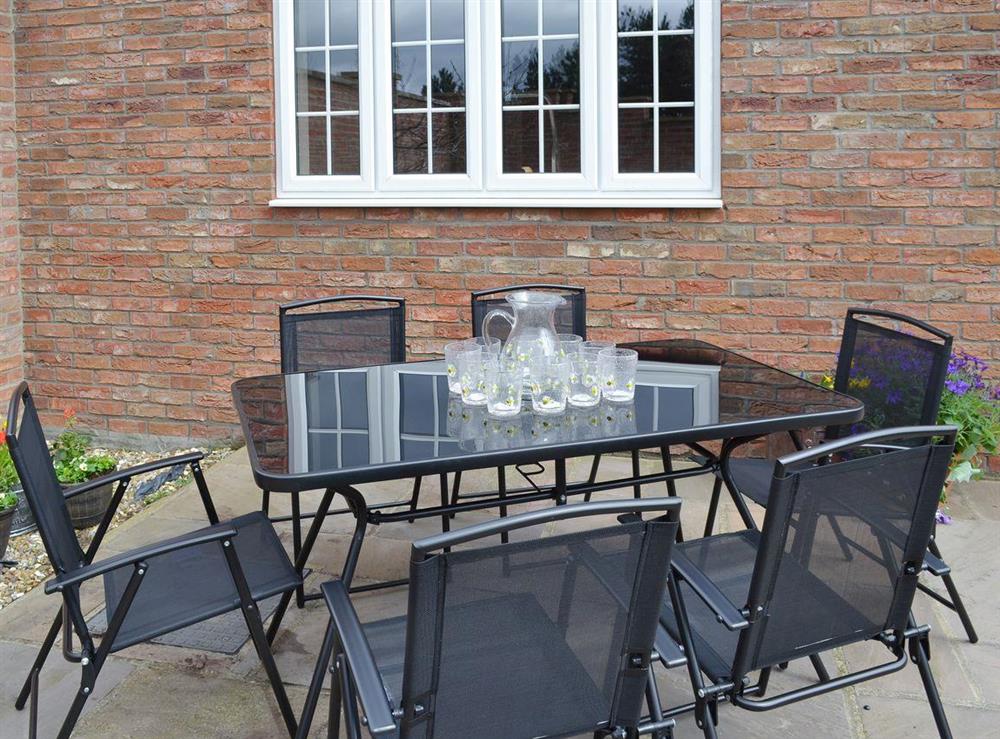 Outdoor eating area with modern furniture at Bumblebee Cottage in Skipsea, near Hornsea, North Humberside