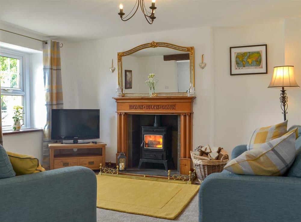 Welcoming living room with a cosy wood burner at Bumblebee Nook in Yanwath, near Penrith, Cumbria