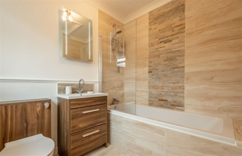 Ground floor: Family bathroom with a bath and shower over, wash basin and WC at Bure Bank, Saxthorpe near Norwich