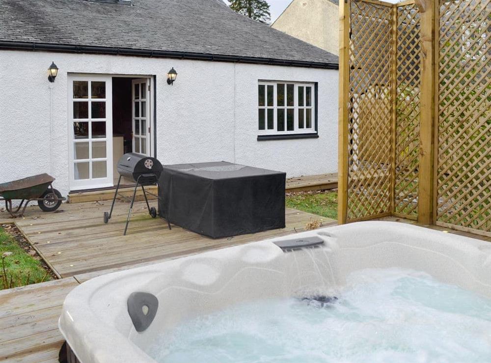 Rear garden area with hot tub and patio at Burnbrae Cottage in Bridgend of Lintrathen, near Forfar, Angus