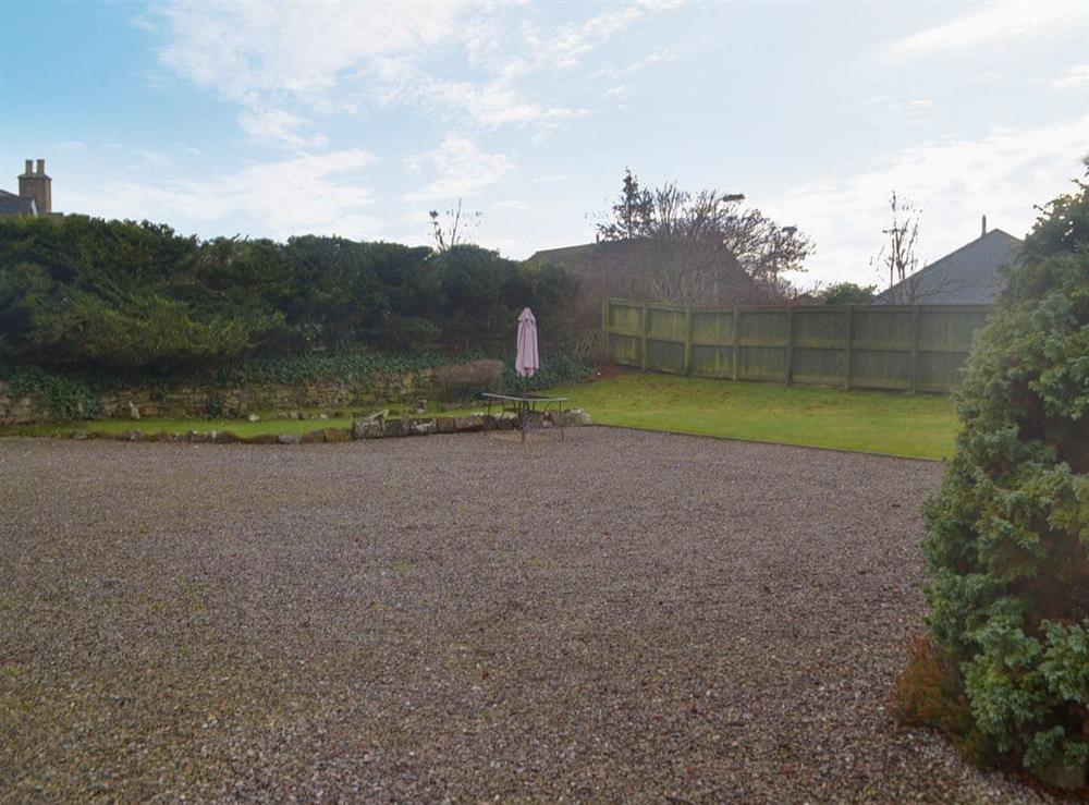 Enclosed lawned garden with sitting-out area, garden furniture and BBQ at Burnside in Dornoch, near Tain, Sutherland