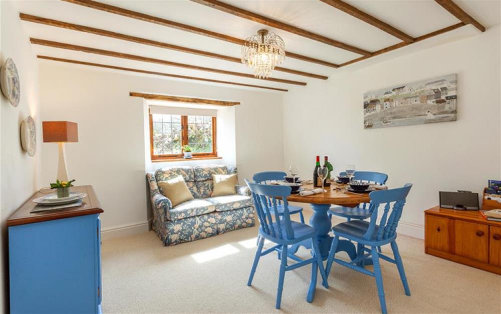 The dining room with table and chairs and a sofa at Burrow Hill Cottage in Honiton