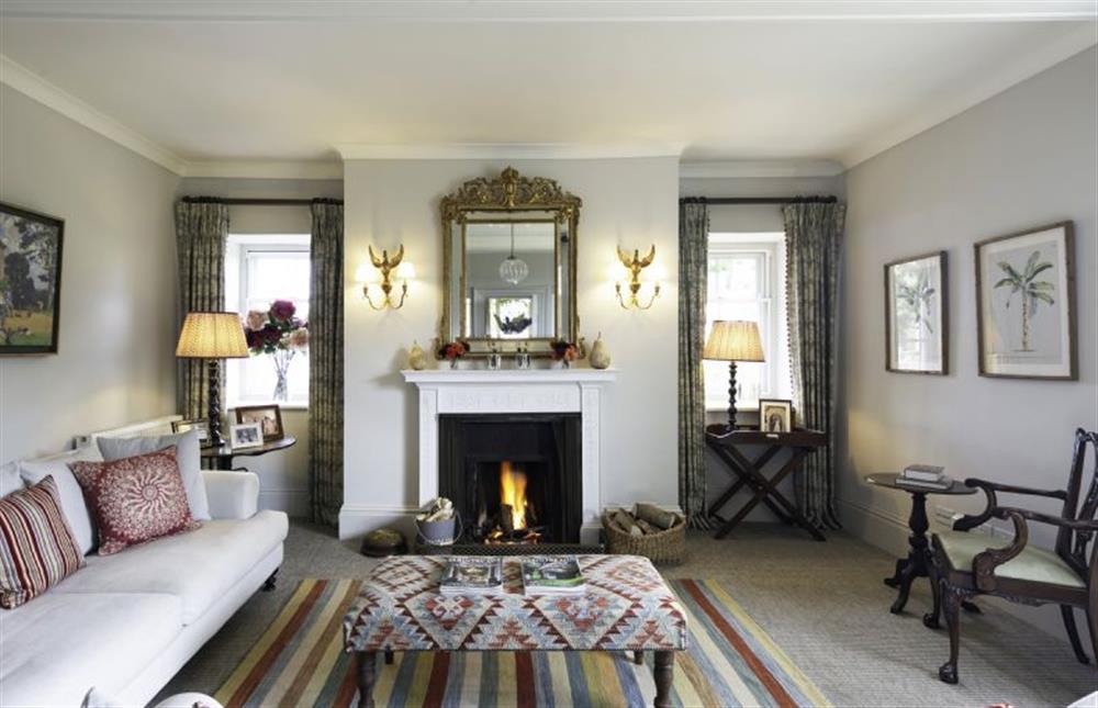 Relax in front of the open-fire in the drawing room  at Butley Priory Farmhouse, Woodbridge