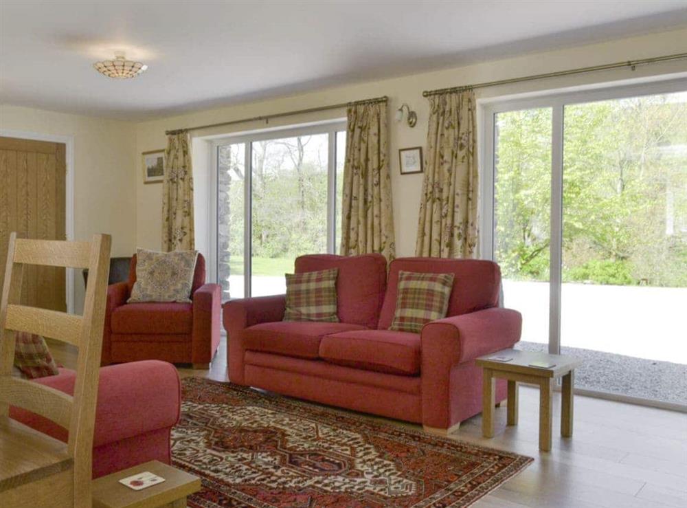 Large picture windows in the living area at Butterfly Cottage in Kendal, Cumbria