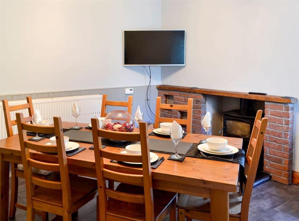 Cosy dining room with wood burner at Butterhole Farmhouse in Mabie, near Dumfries, Dumfriesshire