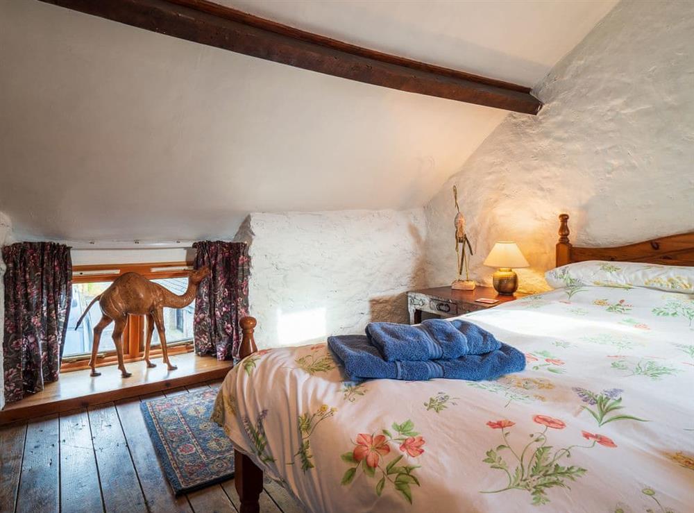 Wooden floored double bedroom with whitewashed walls at Buttermilk Cottage in Youlgreave, near Bakewell, Derbyshire