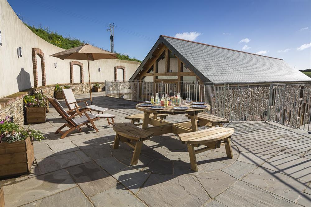Very spacious stone terrace with picnic table, bench seating, sun loungers and a large fire pit at Butterwell Barn in , Nr Dartmouth