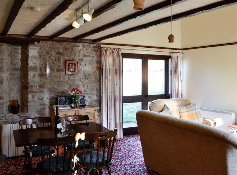 Living room with dining area at Buzzard Cottage in Defynnog, near Brecon, Powys