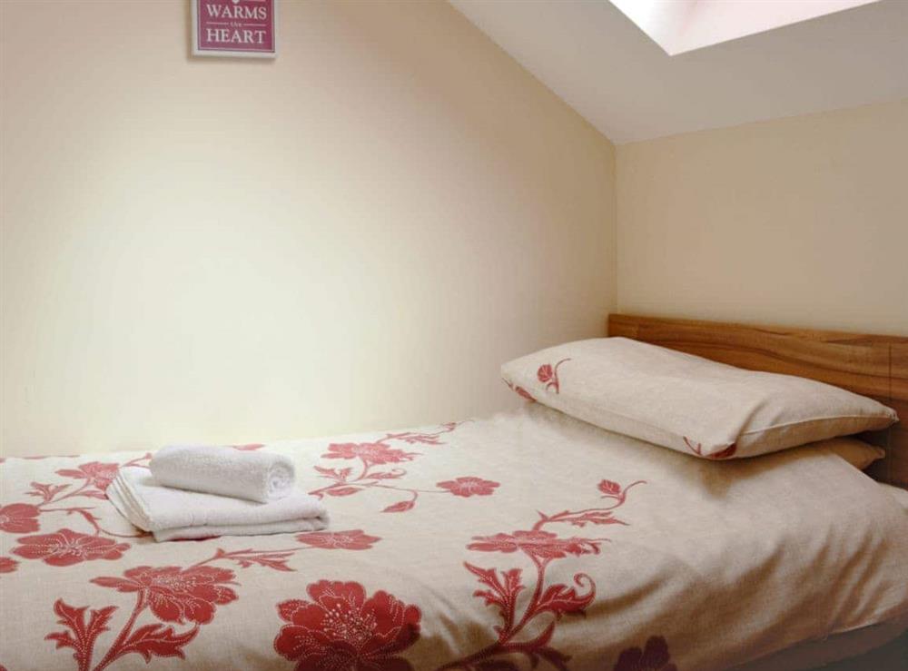 The comfortable twin bedroom has sloping ceilings at Ysgubor Uchaf, 