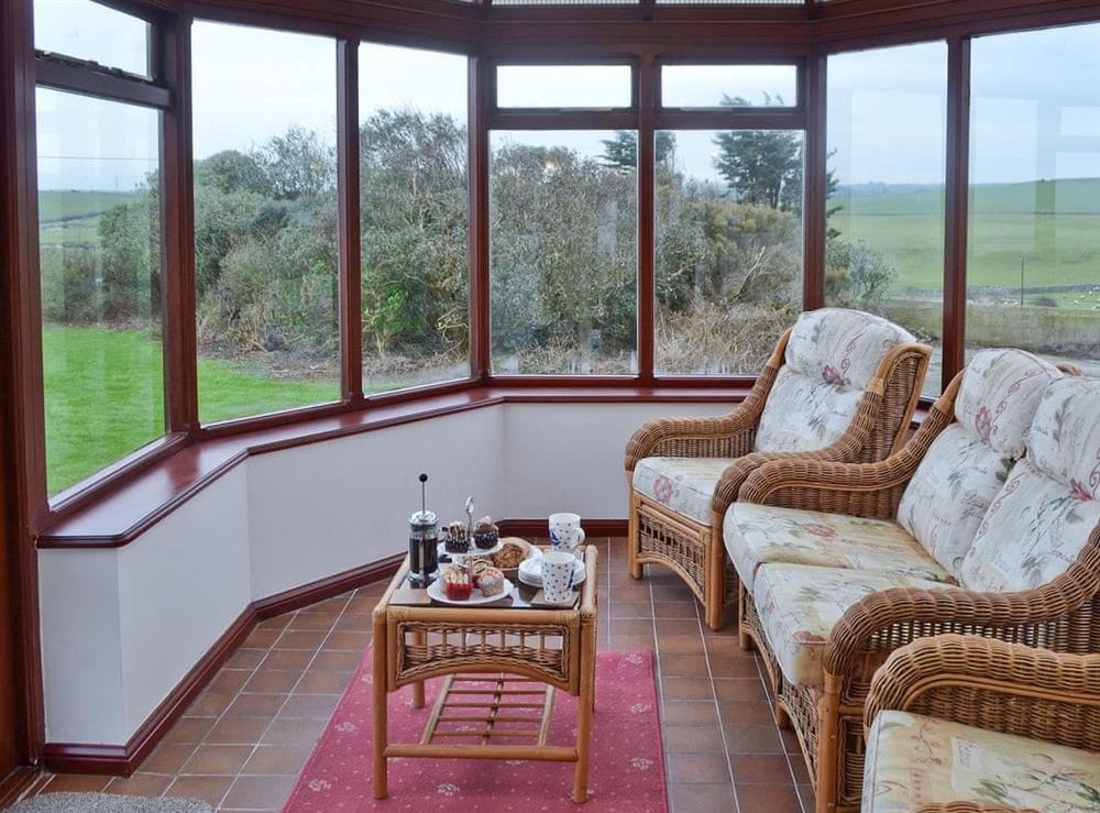 Conservatory overlooking the garden at Bwthyn Pereos in Cemaes Bay, Gwynedd