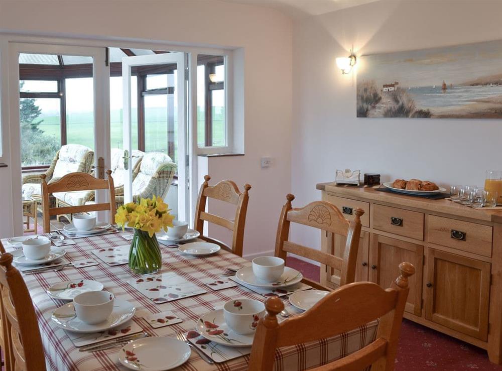 Lovely dining room leading into conservatory at Bwthyn Pereos in Cemaes Bay, Gwynedd