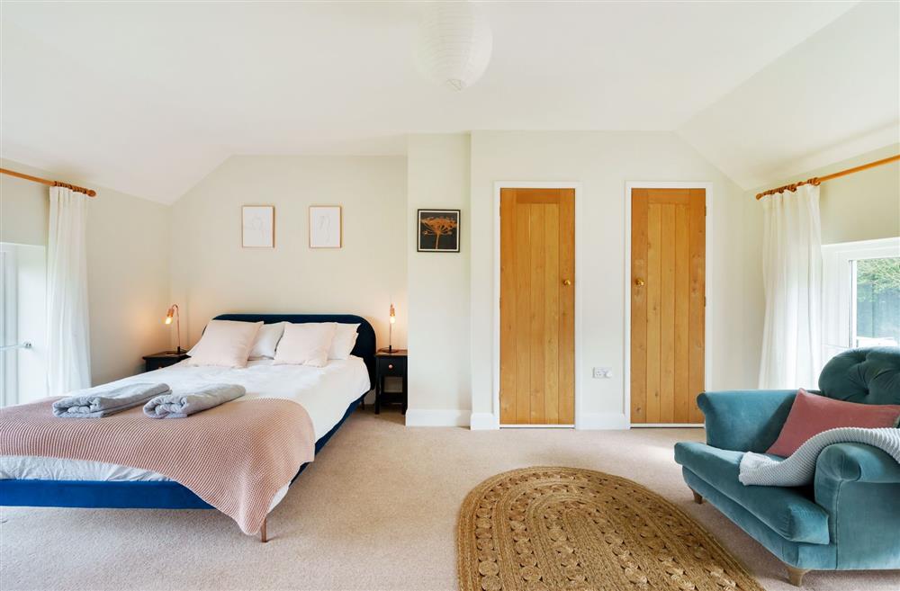 Bedroom one with 5’ king-size bed and an en-suite shower room at Byre House, Blandford