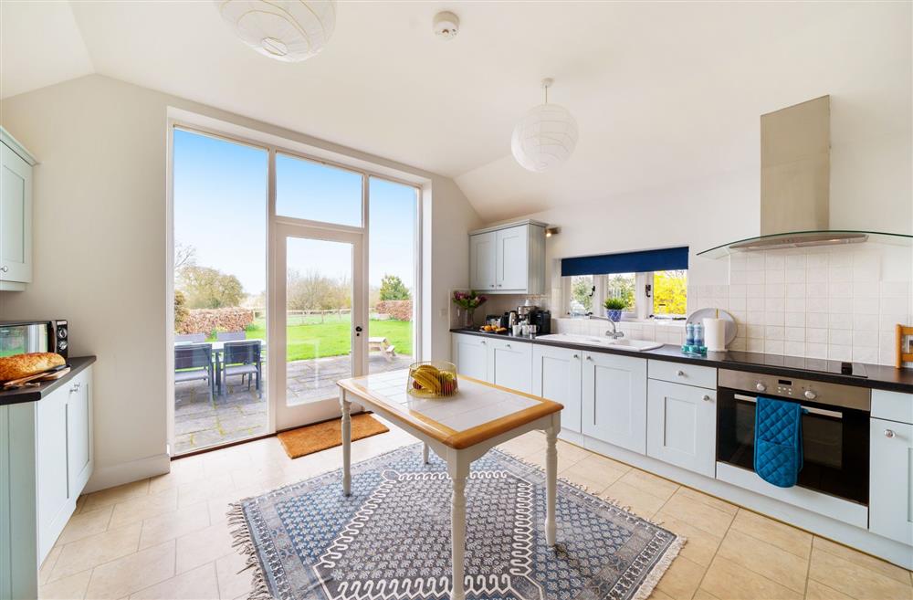 The light-filled kitchen with door leading out to the garden patio at Byre House, Blandford