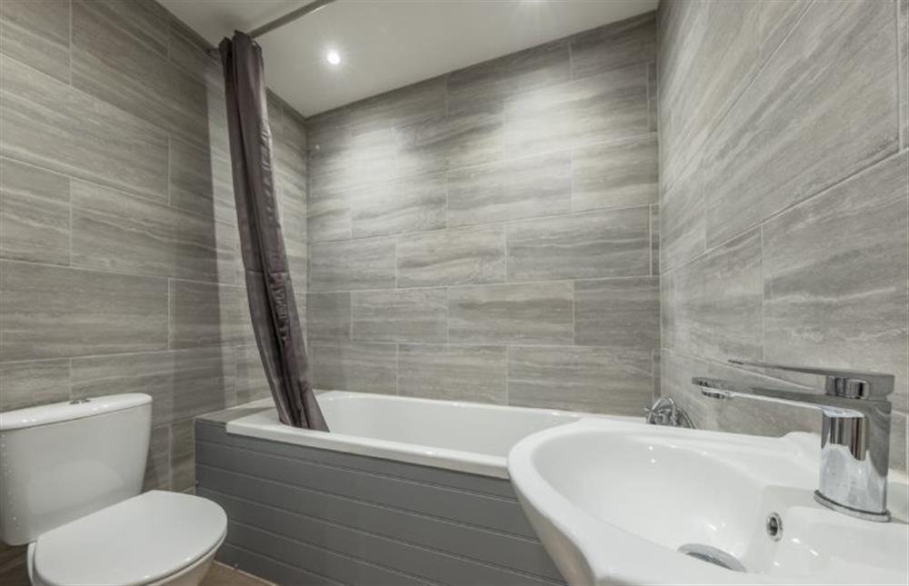 Ground floor: Bathroom with bath with a shower over, wash basin and WC at Cabbell Courtyard, Cromer