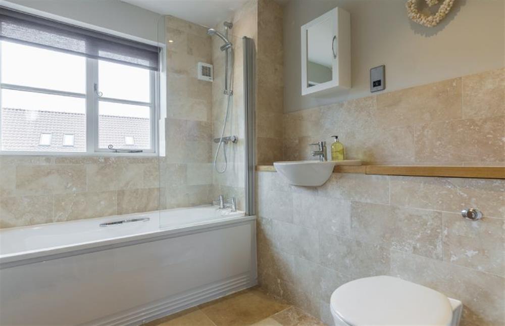 First floor: Family bathroom with shower over bath at Caddows, Docking near Kings Lynn