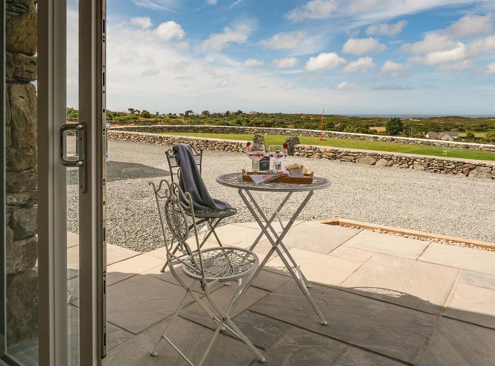 Paved patio with views over the garden to the sea at Pant y Saer, 