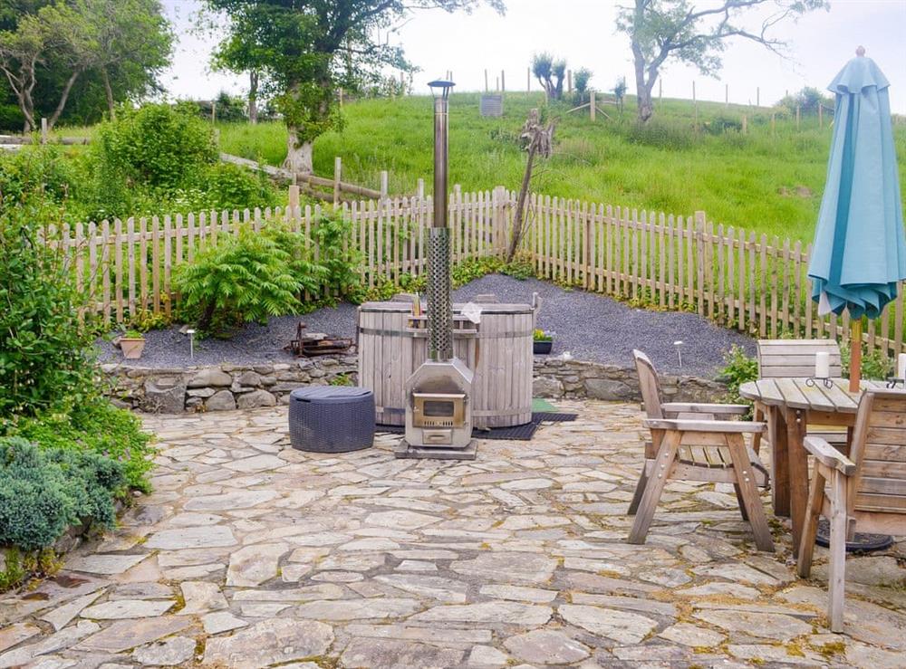 Luxurious wood-fired hot tub within enclosed garden and patio at Caeberllan in Llanfair Caereinion, Powys