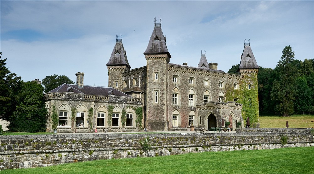An exterior shot of Newton House with a green meadow in front of it at Caerllan in Llandysul, Ceredigion