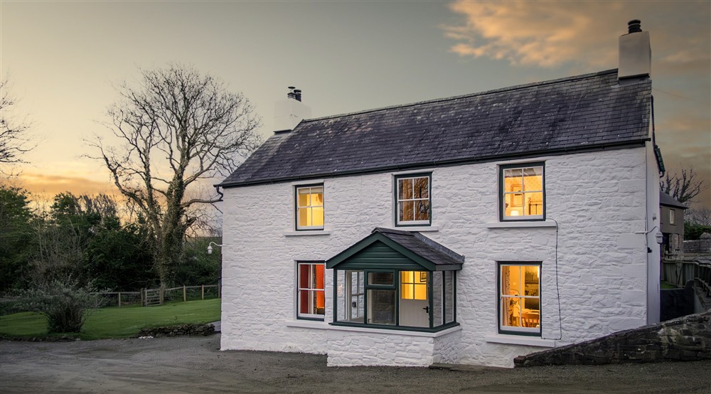 The exterior of Caerllan in the evening, with lights coming from the windows, Ceredigion at Caerllan in Llandysul, Ceredigion