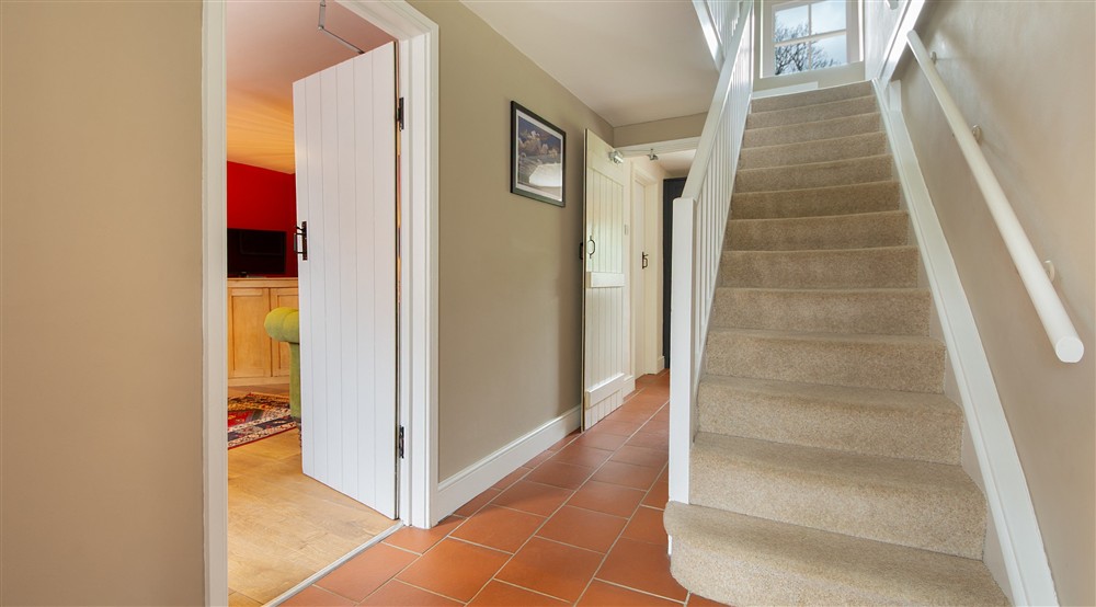 The red-tiled hallway and carpeted staircase at Caerllan in Llandysul, Ceredigion
