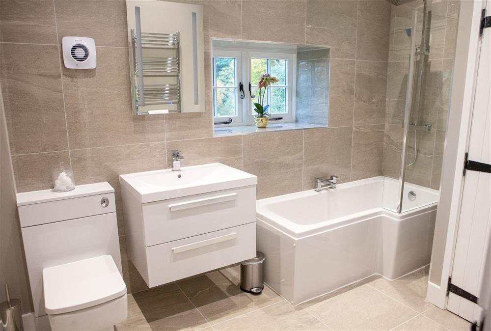 Family bathroom with a bath and overhead shower at Calcot Farmhouse, Montgomery