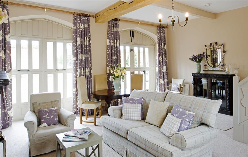 The sitting room with dining area is a spacious room featuring high ceilings at Callander Cottage, Whitchurch