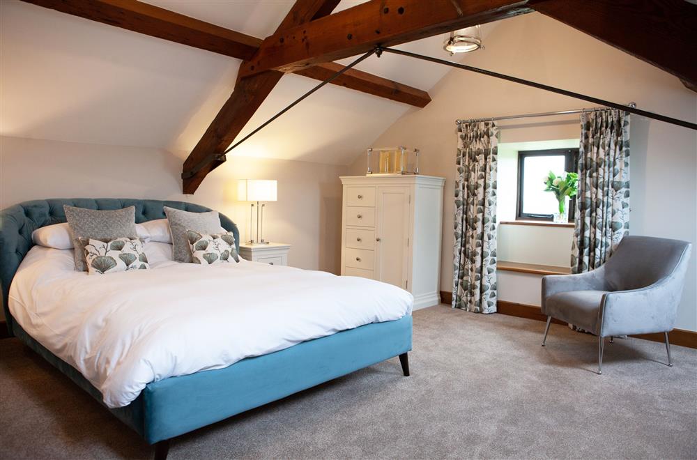 Kingfisher bedroom with 5’ king-size bed and exposed beams at Camlad Barn, Montgomery