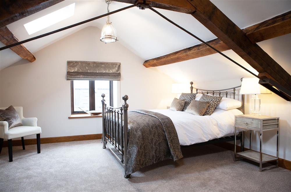 Otter bedroom with 5’ king-size bed and exposed beams at Camlad Barn, Montgomery