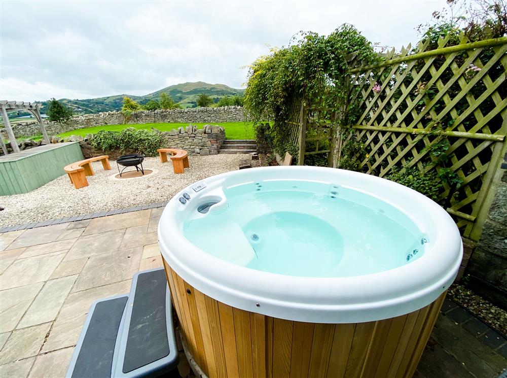 Relax in the hot tub while taking in the countryside views at Camlad Barn at Camlad Barn, Montgomery