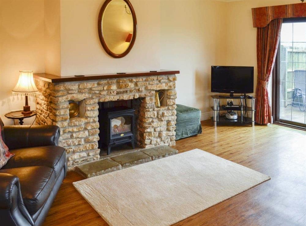 Large living room with feature fireplace at Canon Court Farmhouse in Milborne Port, near Sherborne, Dorset