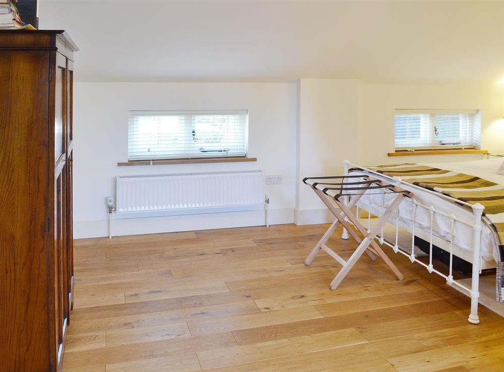 Oak floors and matching furniture make the bedroom a warm and welcoming room at The Gardeners Cottage, 