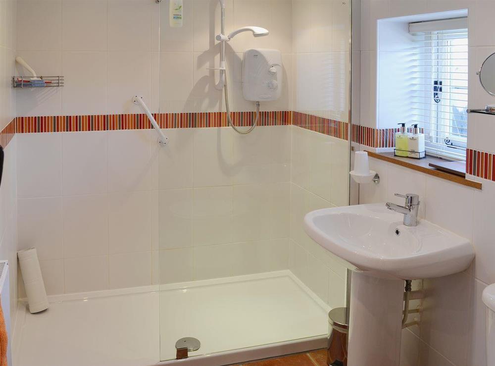 The fully-tiled shower room has a large walk in shower at The Gardeners Cottage, 