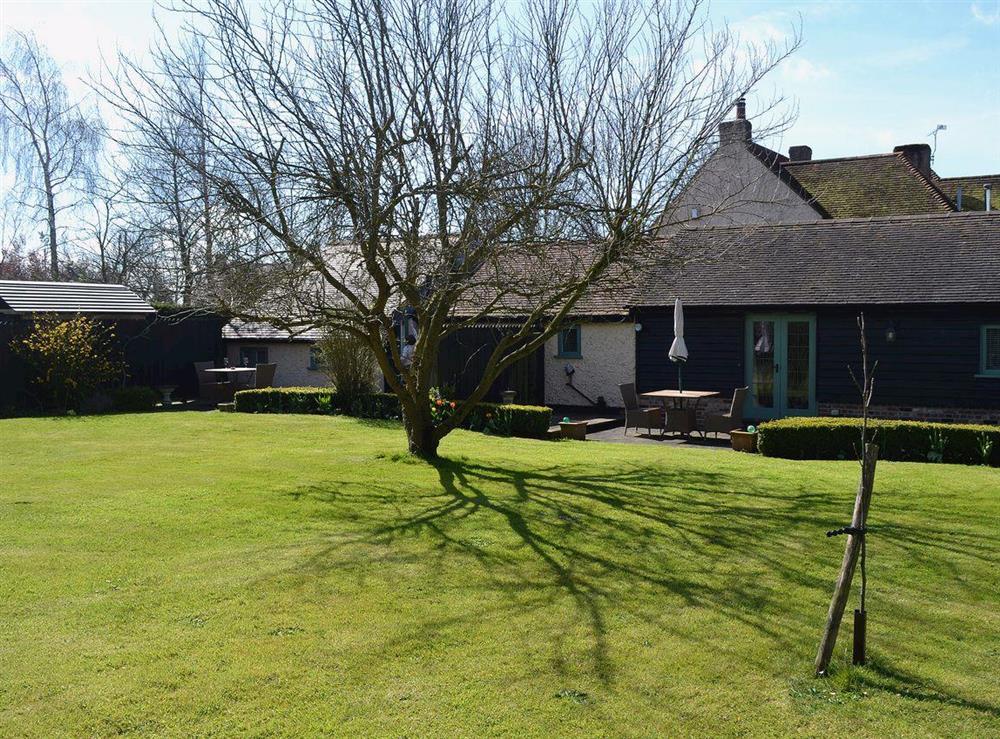 The property has a large shared garden with mature trees and lawned area at The Gardeners Cottage, 
