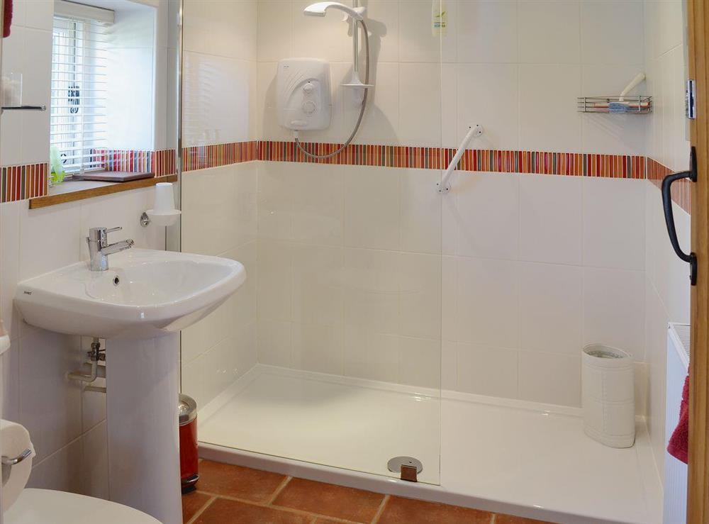 The shower room has a large walk in full height shower and is tiled throughout at The Stables, 