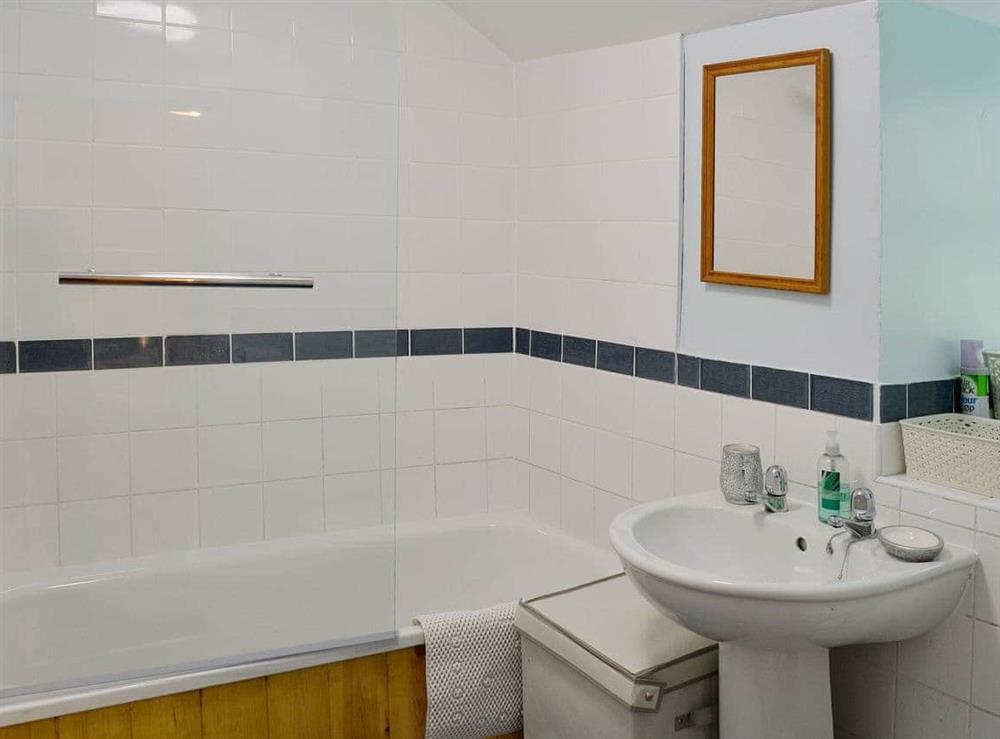 The bathroom has a shower over the bath and a heated towel rail at Capel Fawnog Bach in Talsarnau, Gwynedd
