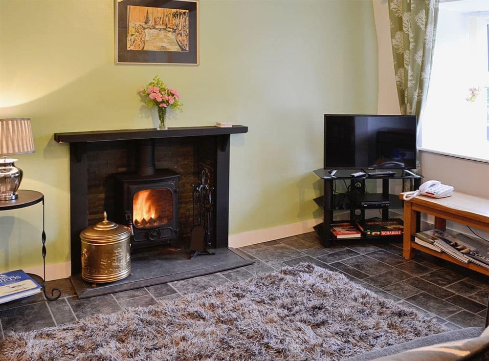 Living/Dining room with open fireplace and woodburner at Capel Fawnog Mawr in Talsarnau, Gwynedd