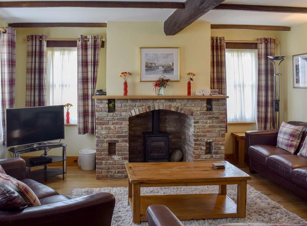 Beamed living room with wood burner at Captains Cottage in Whitby, North Yorkshire