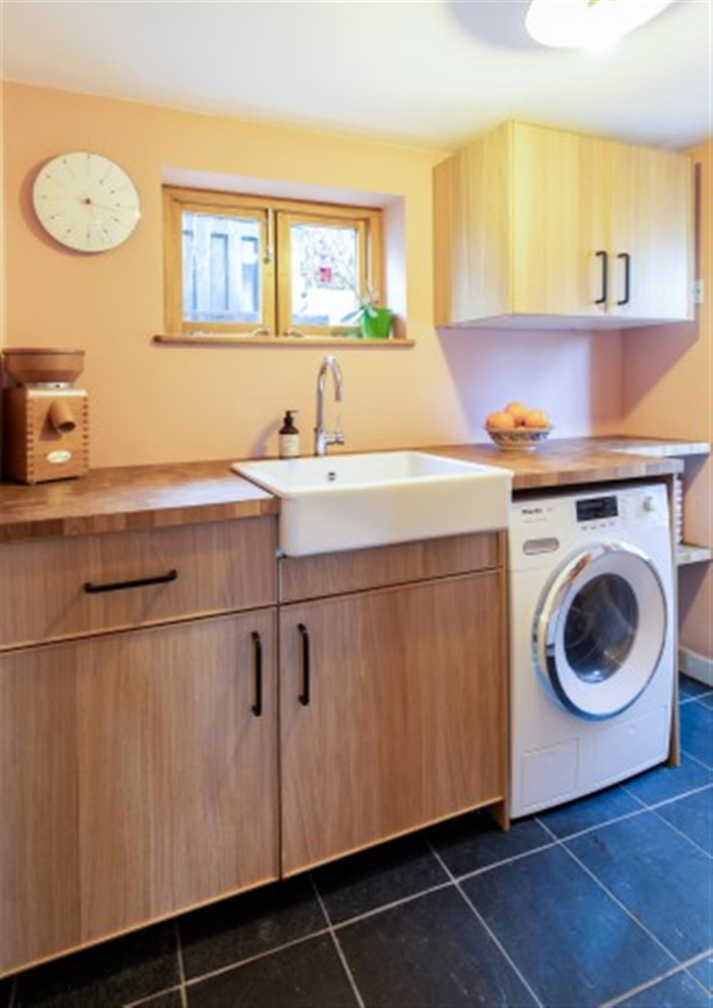 In the utility room, there's a Miele washing machine and belfast sink. at Carabone Cottage in The Lizard