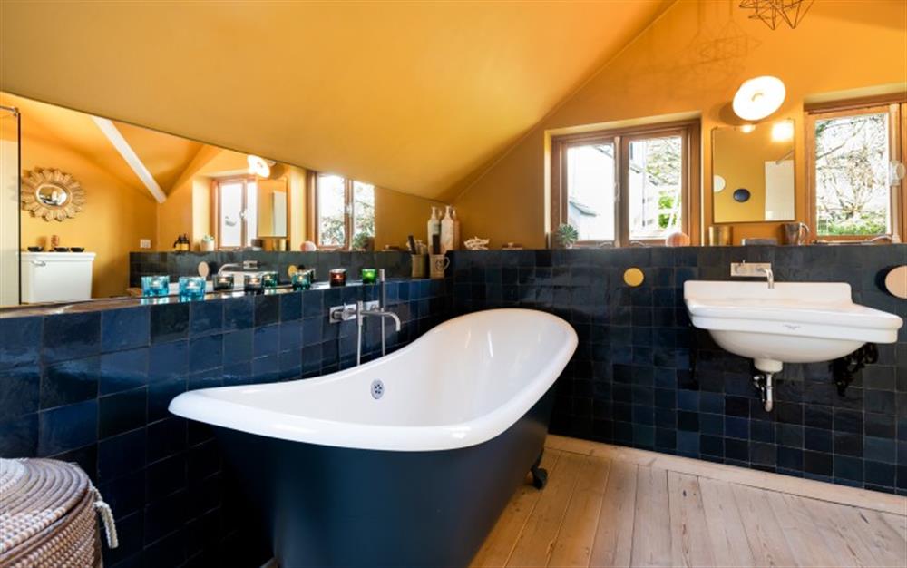There's a real feel of luxury in the bathroom with its deep colours and double-ended slipper top bath. at Carabone Cottage in The Lizard
